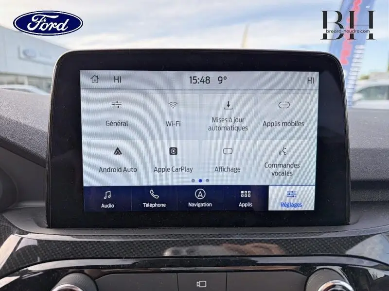 Écran tactile central du Ford Kuga 2023 affichant les réglages connectivité et applications, vue intérieure frontale.