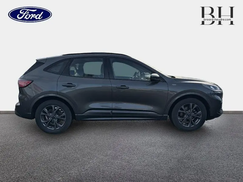 Vue latérale droite du Ford Kuga 2023 gris Magnetic métallisé avec jantes alliage et lignes sportives marquées.