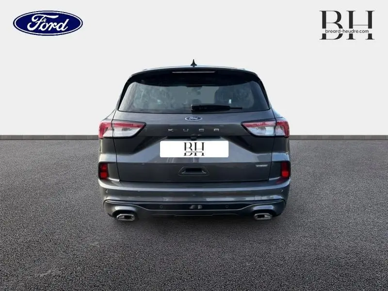 Vue arrière du Ford Kuga 2023 gris Magnetic Métallisé avec double sortie d’échappement et hayon mains libres.