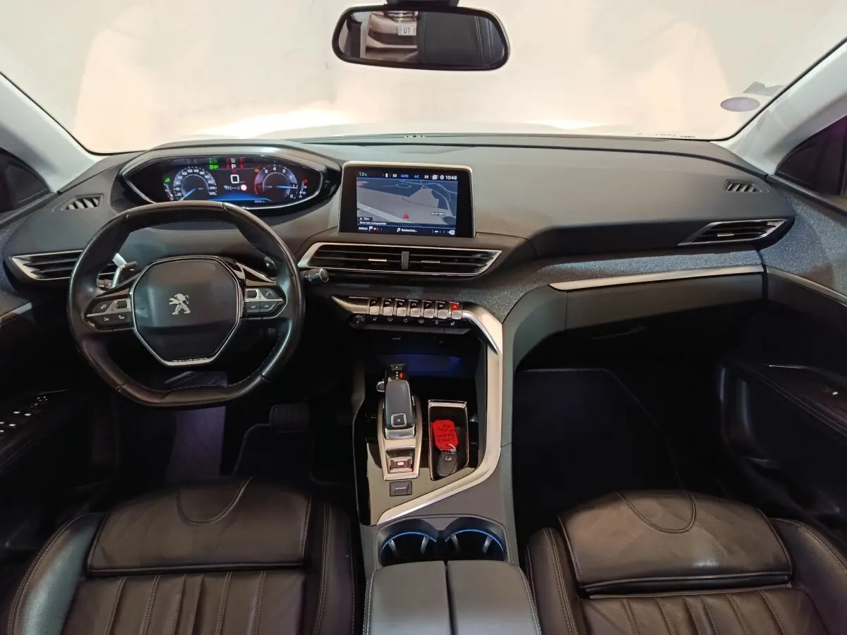 Vue intérieure avant du Peugeot 3008 blanc 2019, tableau de bord moderne avec écran tactile et volant cuir multifonctions.