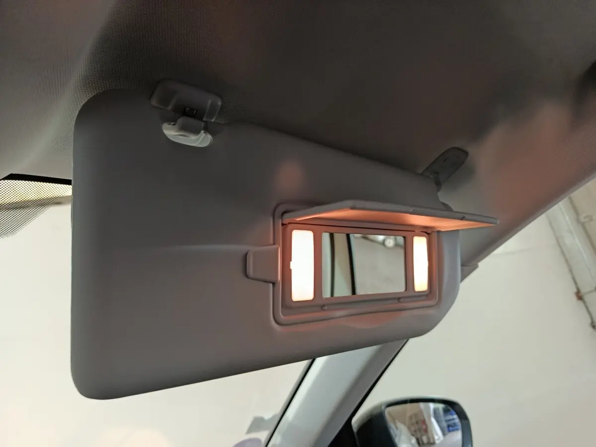 Détail du pare-soleil côté conducteur avec miroir éclairé dans un Peugeot 3008 blanc, vue intérieure.