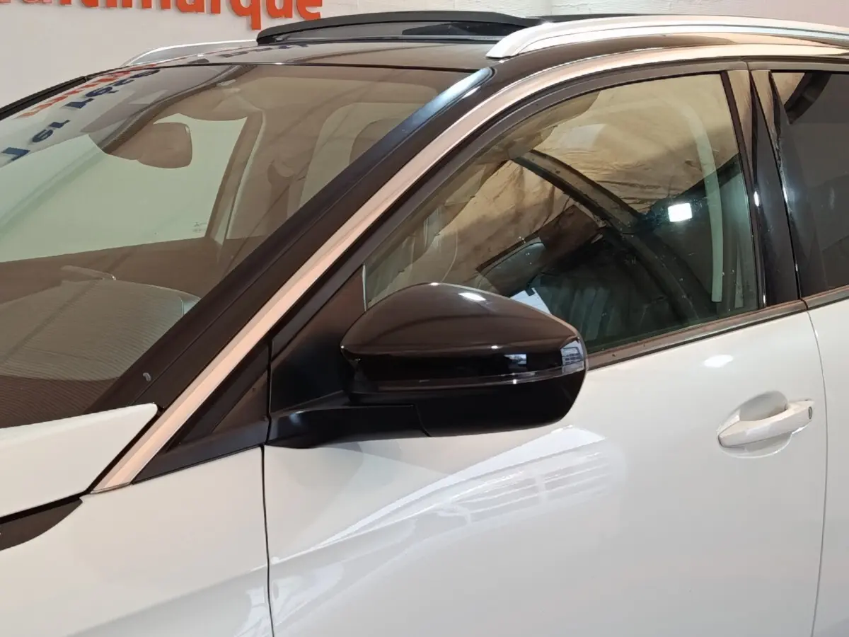 Vue rapprochée côté gauche avant d’un Peugeot 3008 blanc avec rétroviseur noir brillant et toit panoramique.
