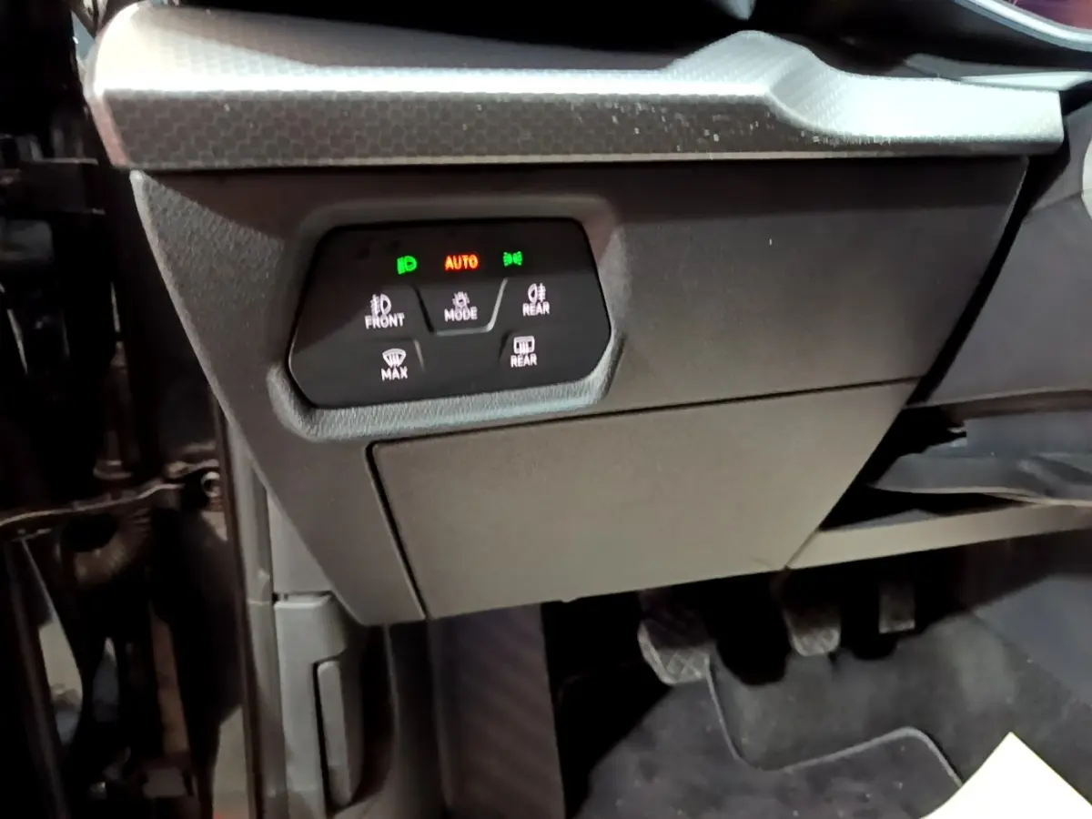 Gros plan sur le tableau de bord côté conducteur du SEAT Leon 2023, montrant les commandes d’éclairage et les pédales noires.