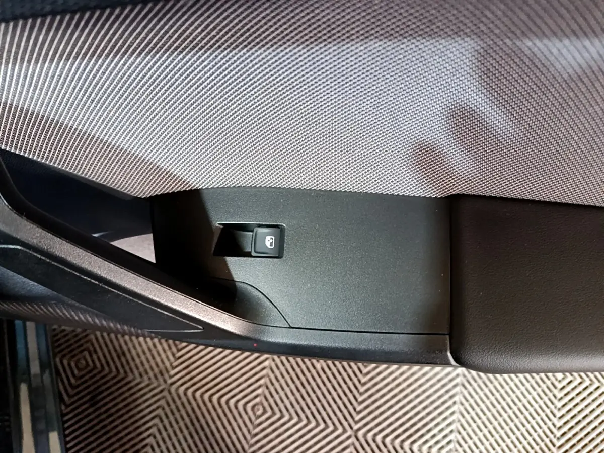 Détail de l’accoudoir intérieur côté gauche du SEAT Leon 2023 avec bouton de verrouillage des portes.