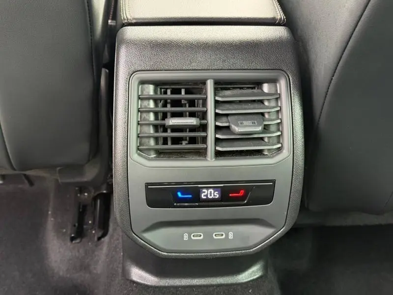 Détail de la ventilation arrière et commandes de climatisation digitale sur le siège arrière d’un CUPRA Formentor blanc Nevada.
