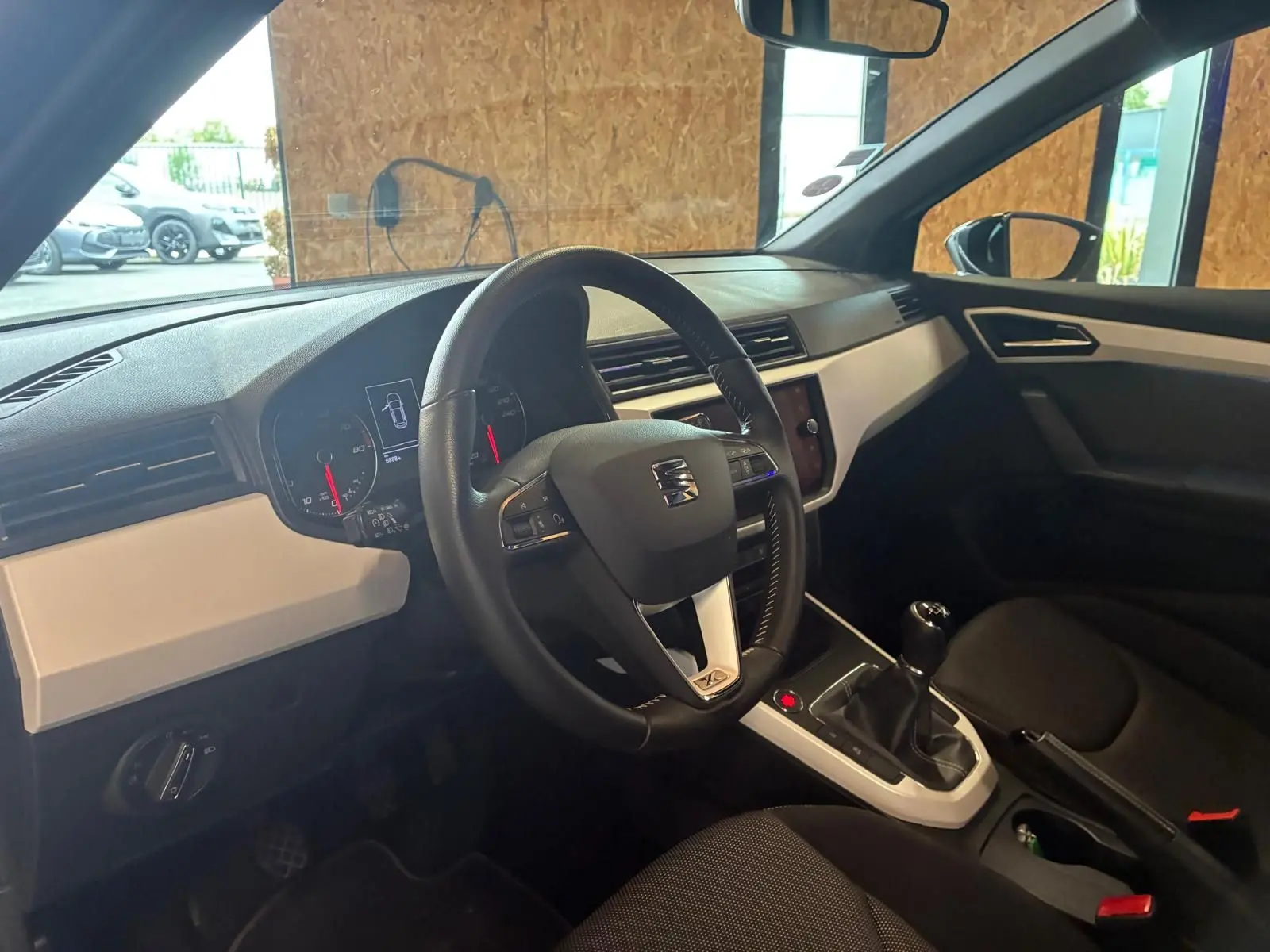 Intérieur du SEAT Arona 1.0 TSI 110 XCELLENCE 2021, vue côté conducteur, tableau de bord noir avec inserts gris clair.