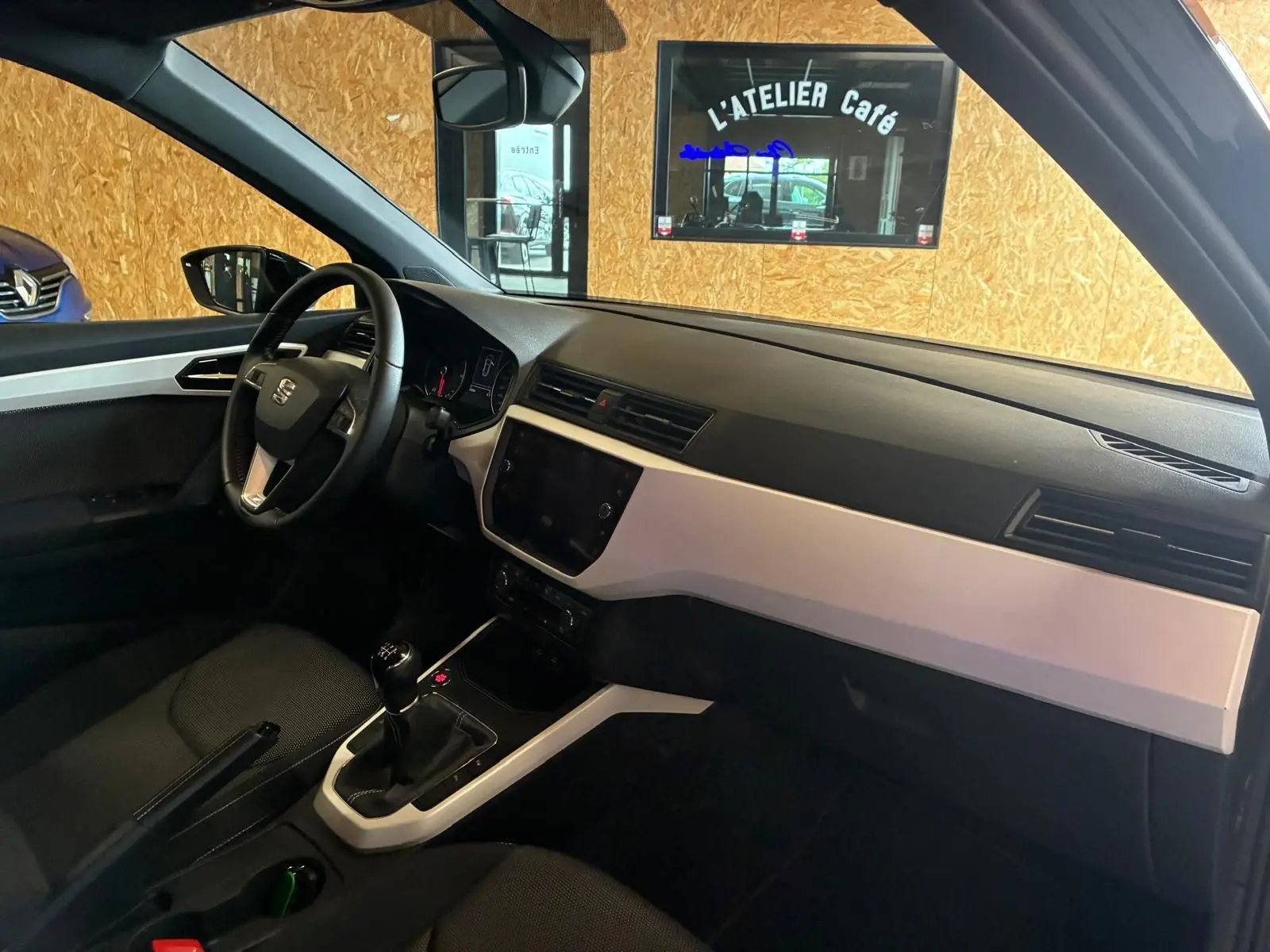 Intérieur avant droit du SEAT Arona gris foncé 2021, tableau de bord noir et beige avec boîte manuelle visible.