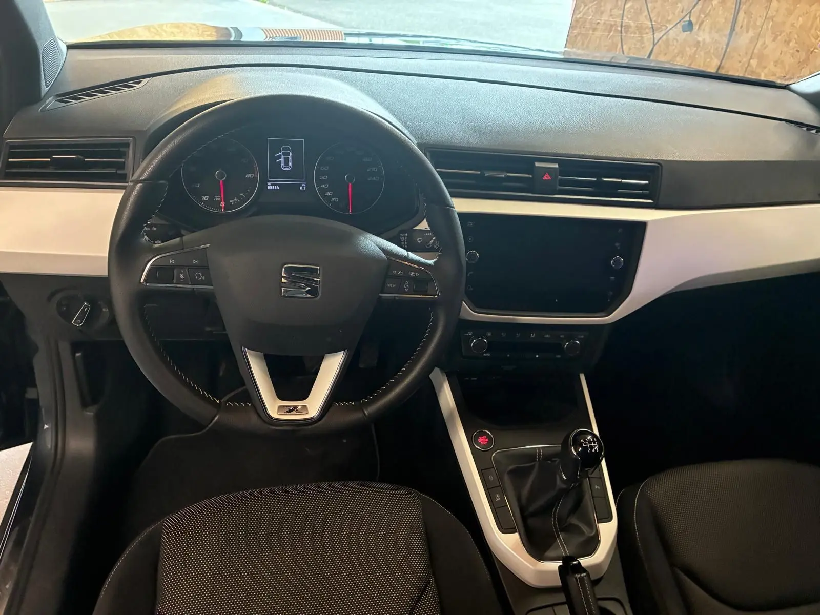 Vue intérieure frontale du tableau de bord noir et gris du SEAT Arona 1.0 TSI 110 XCELLENCE avec boîte manuelle.