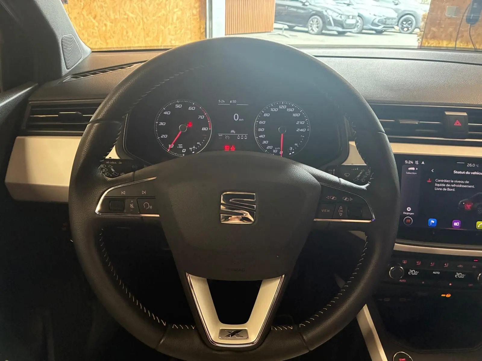 Vue centrée sur le volant noir du SEAT Arona gris foncé 2021, avec tableau de bord et écran tactile visibles.