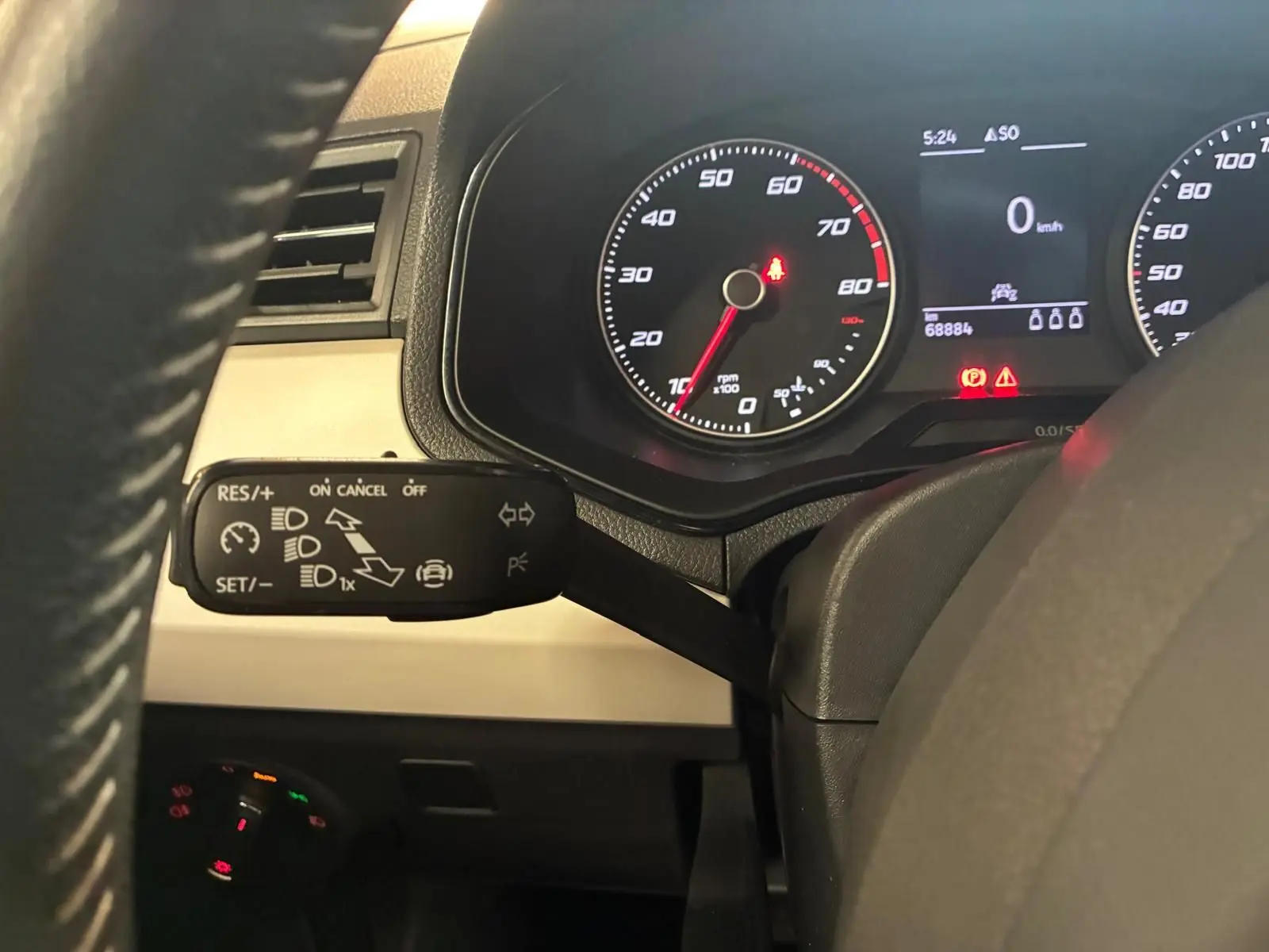 Vue rapprochée du tableau de bord du SEAT Arona gris foncé, mettant en avant le levier de commande du régulateur de vitesse.