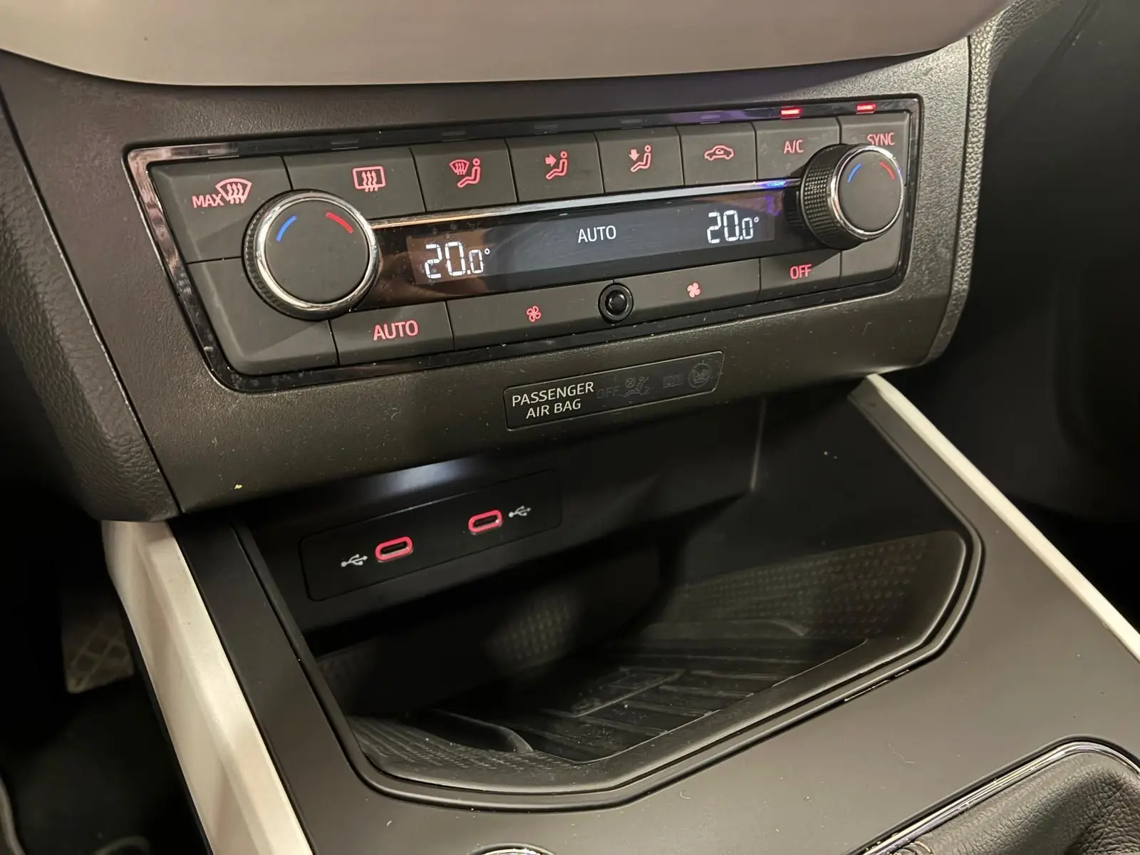 Gros plan sur la console centrale du SEAT Arona 2021, montrant la climatisation digitale et ports USB rouges.