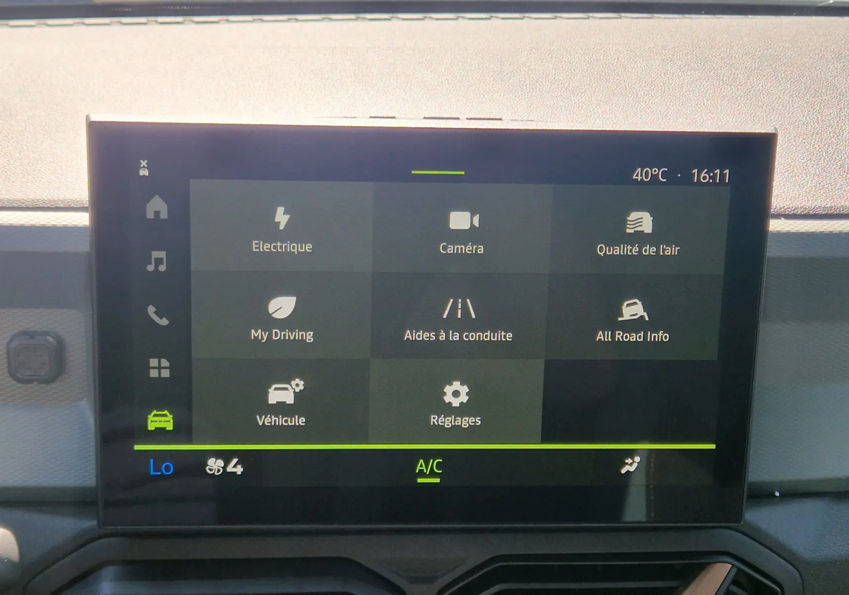 Écran tactile central du Dacia Duster blanc 2026 montrant le menu principal avec options de conduite et climatisation.