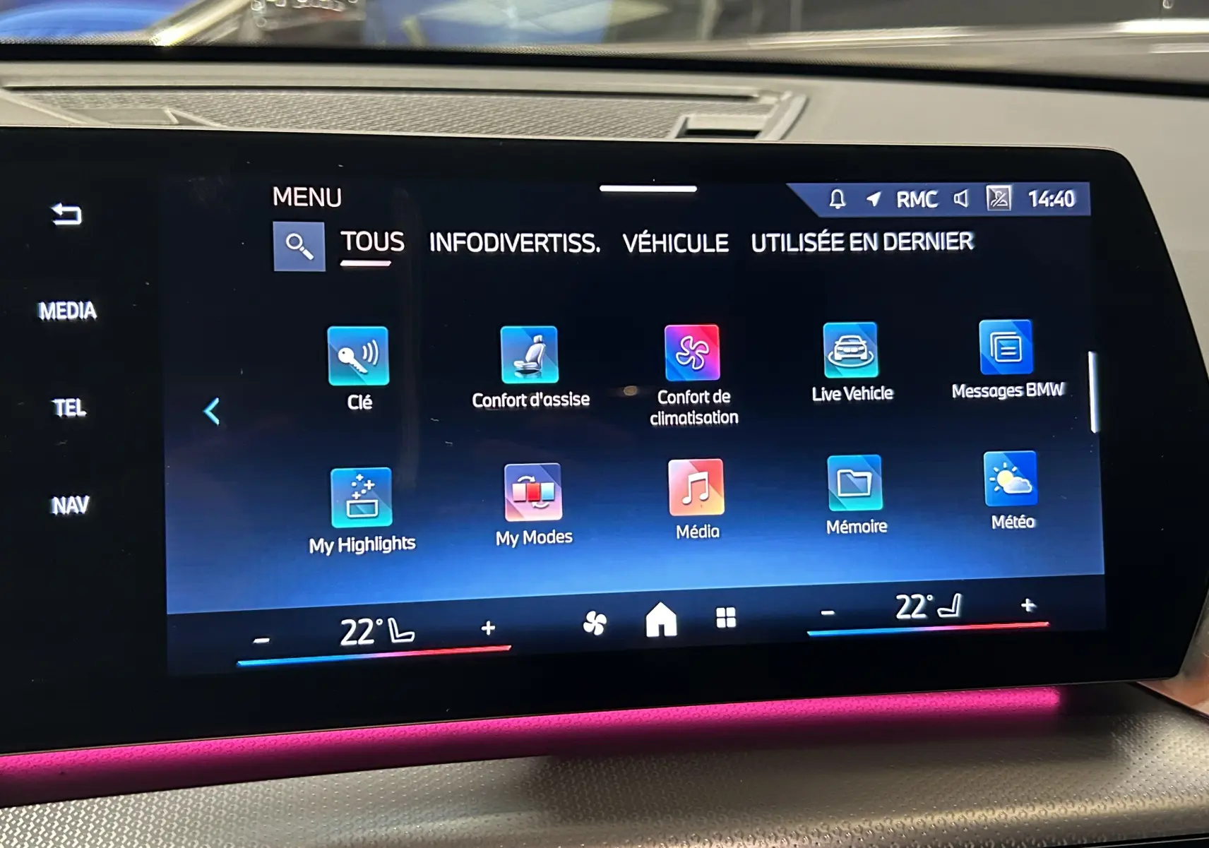 Écran tactile central du BMW X1 2024 affichant le menu principal avec ambiance lumineuse intérieure rose visible.