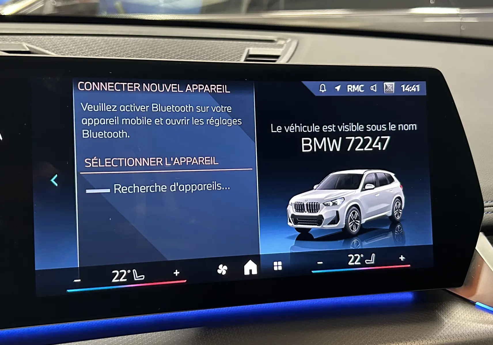 Écran tactile intérieur affichant une illustration 3/4 avant d'un BMW X1 Spacesilber sur fond bleu.