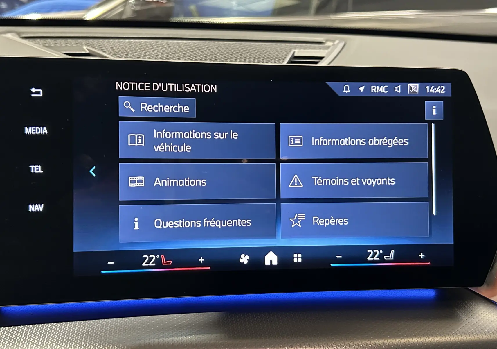 Écran tactile central du BMW X1 2024 affichant le menu d'utilisation avec ambiance lumineuse bleue intérieure