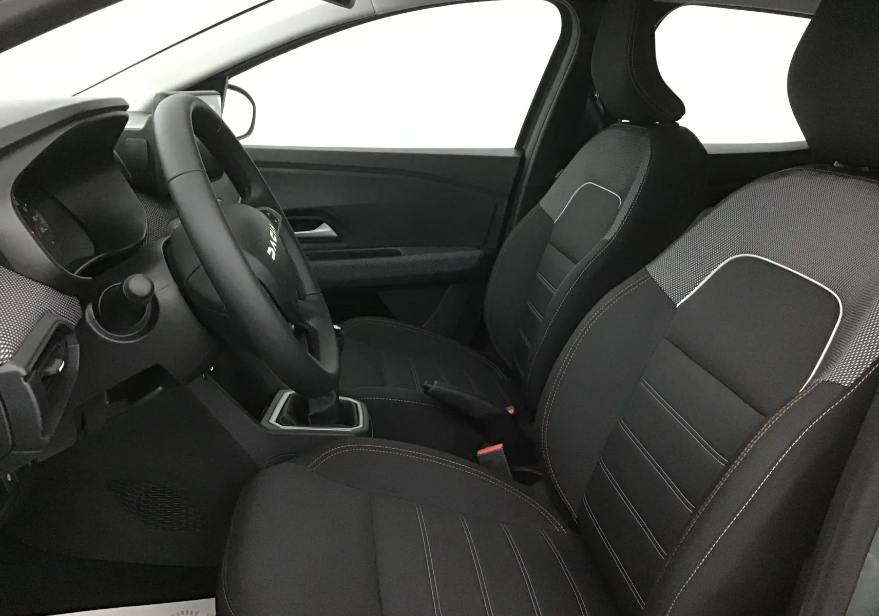 Vue intérieure côté conducteur de la Dacia Sandero Stepway 2025 avec sièges chauffants en sellerie noire Stepway.