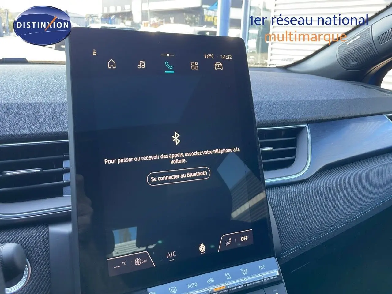 Écran tactile central allumé dans l'habitacle du Renault Captur bleu Iron Metal avec toit noir, vue côté passager.