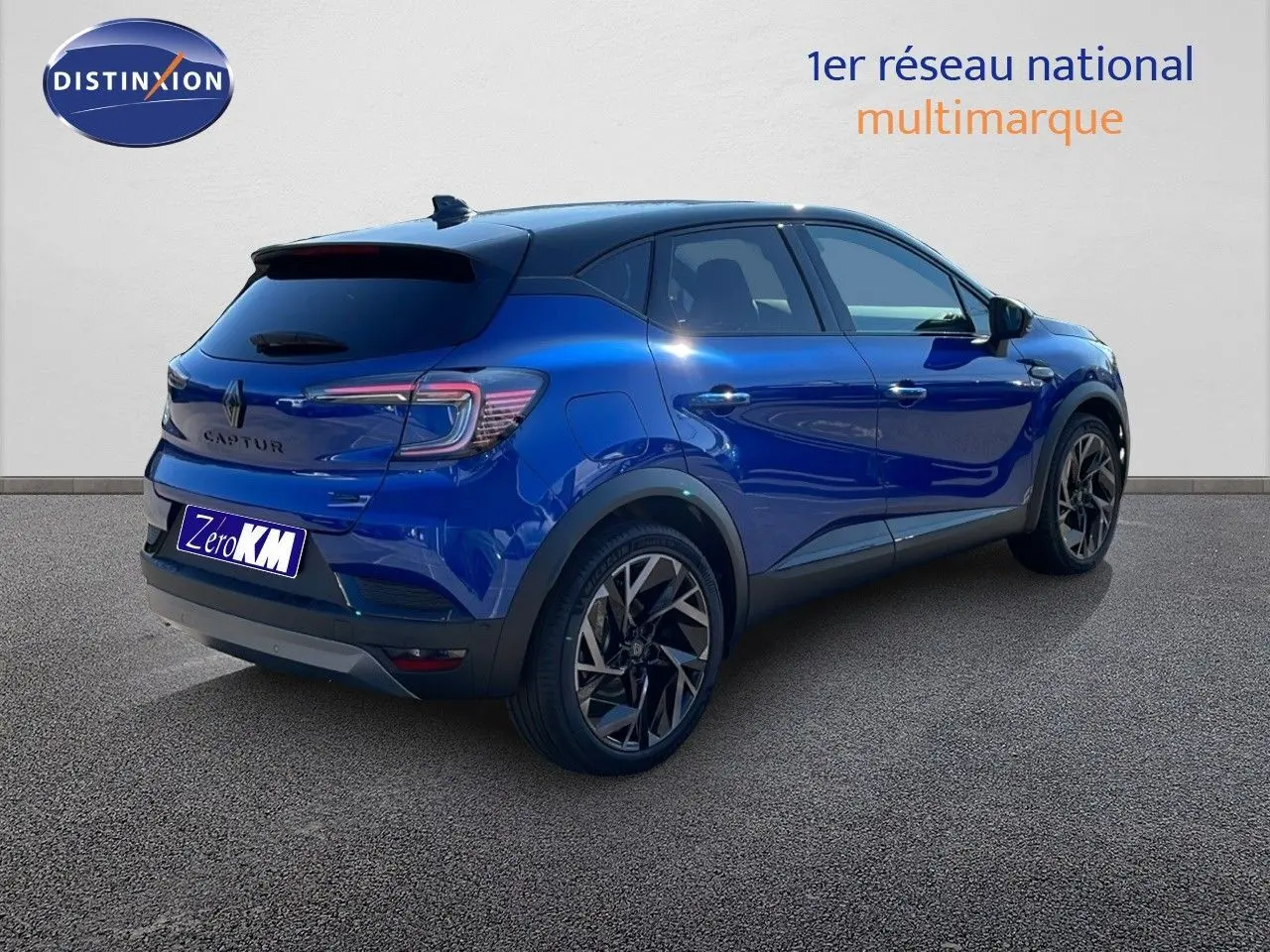 Vue 3/4 arrière droite du Renault Captur E-Tech hybride bleu Iron Metal avec toit noir et jantes noires.