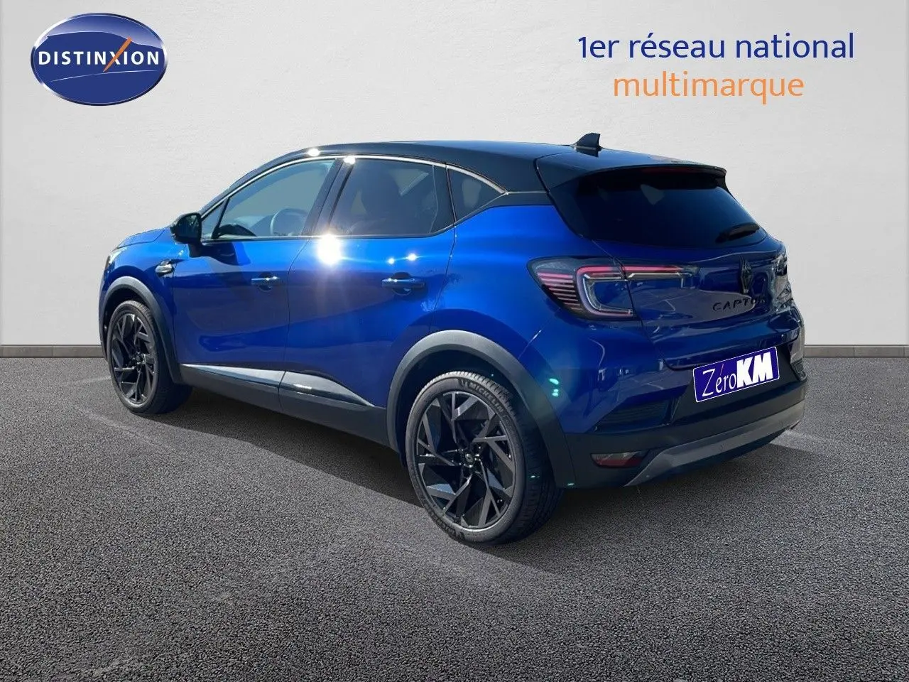 Vue 3/4 arrière droite du Renault Captur E-Tech hybride bleu Iron Metal avec toit noir et jantes noires.