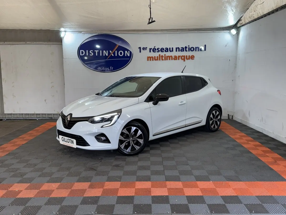 Renault Clio Business blanc vue 3/4 avant droit en intérieur avec jantes noires et rétroviseurs noirs.