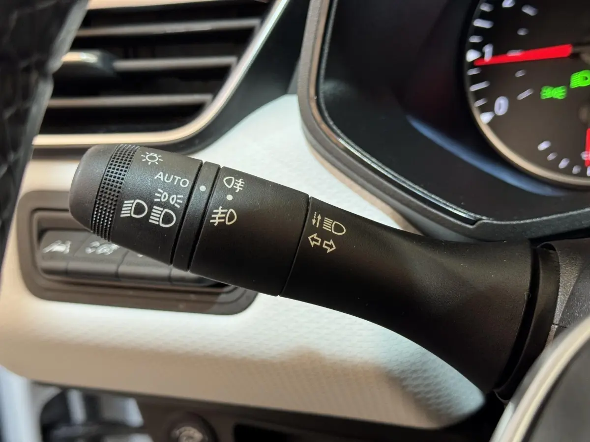 Gros plan sur la commande des phares et clignotants dans l’habitacle blanc d’une Renault Clio Business TCe 100 GPL 2023.
