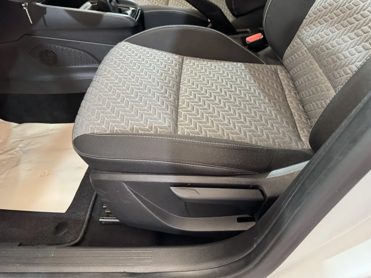 Gros plan sur le siège avant droit gris à motifs de la Renault Clio Business TCe 100 GPL blanche, intérieur côté passager.