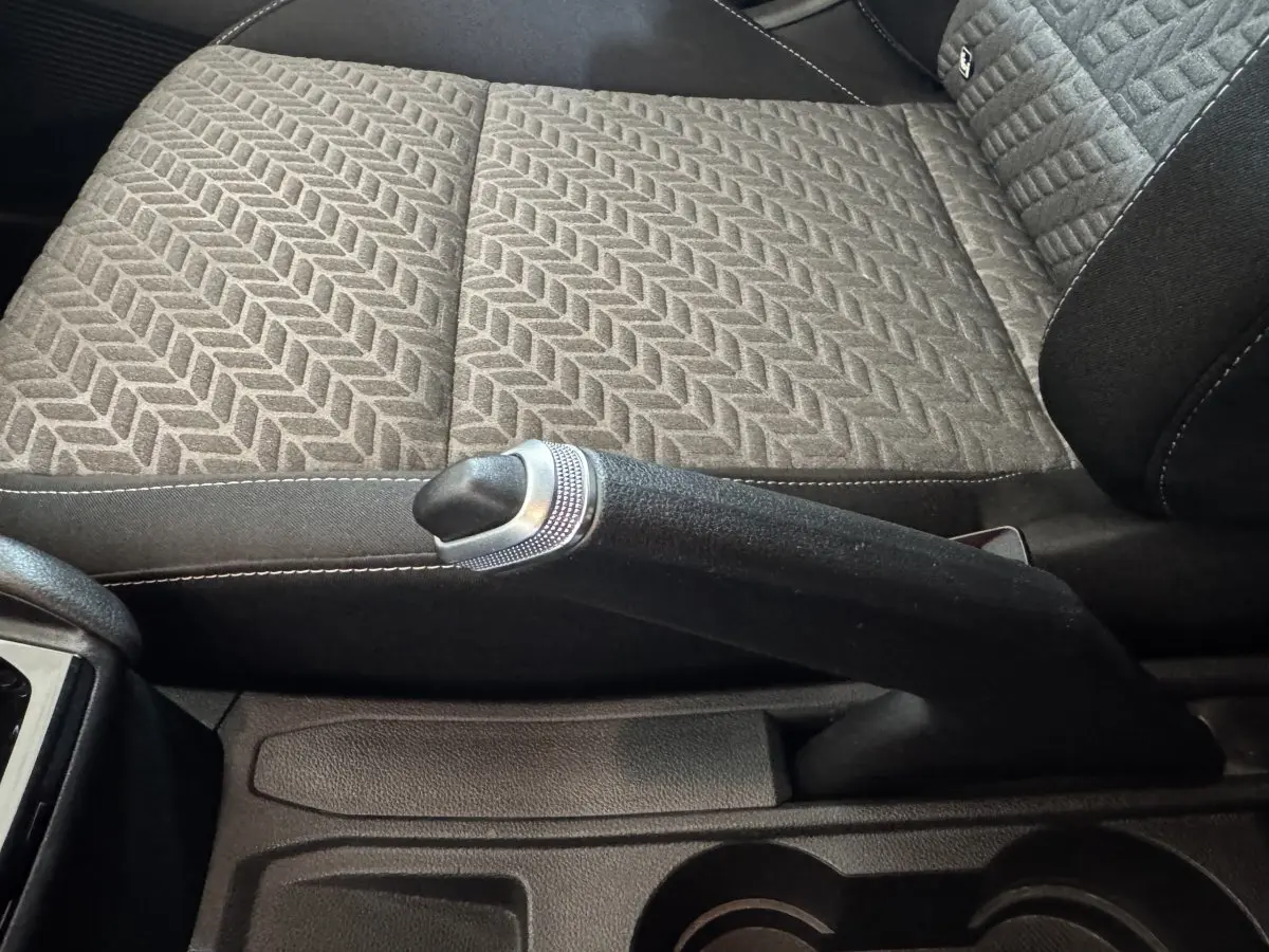 Gros plan sur le frein à main et la sellerie grise à motif chevrons de la Renault Clio Business 2023.