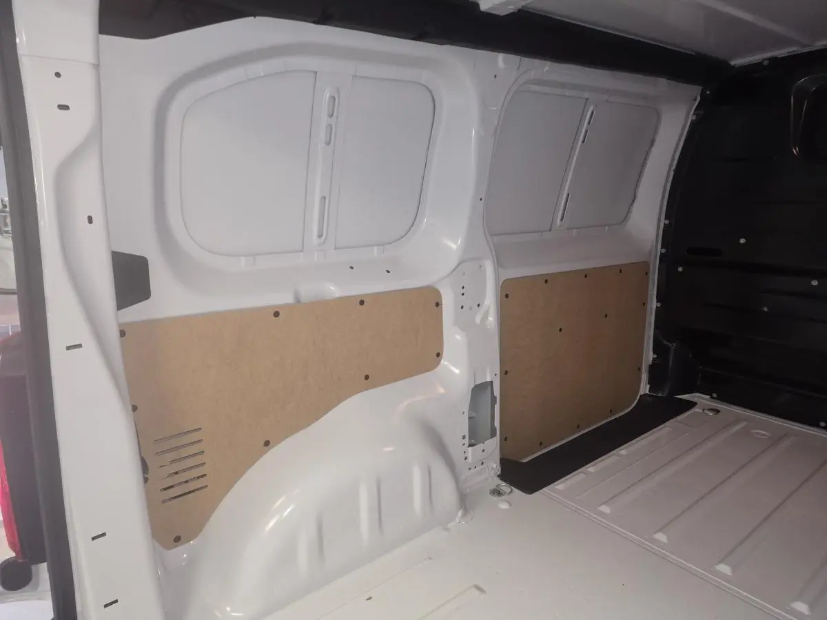 Vue intérieure arrière du fourgon blanc Opel Vivaro 2025, montrant les parois latérales avec panneaux de protection en bois.