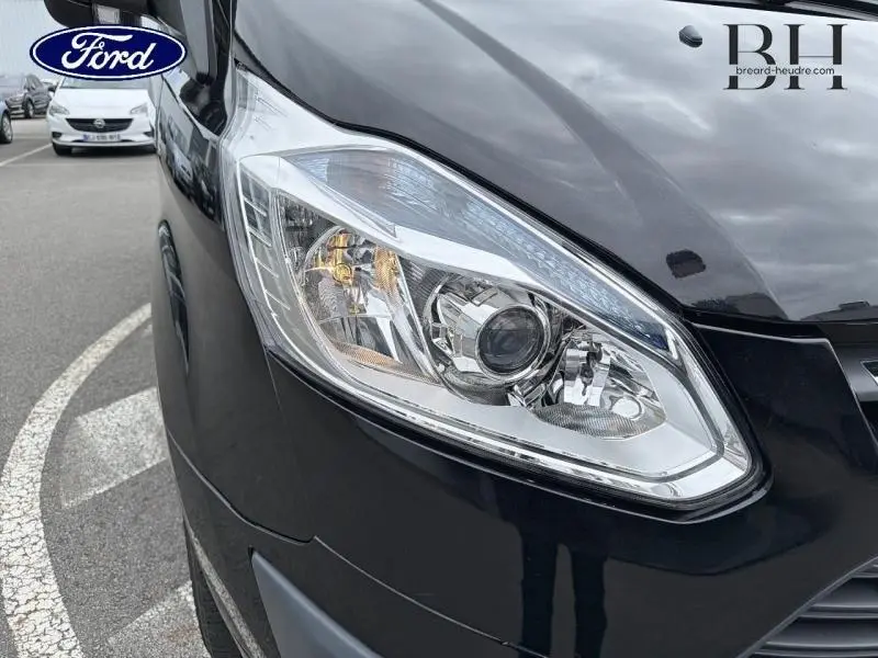 Gros plan sur le phare avant droit du fourgon Ford Transit Custom noir, soulignant son design moderne et précis.