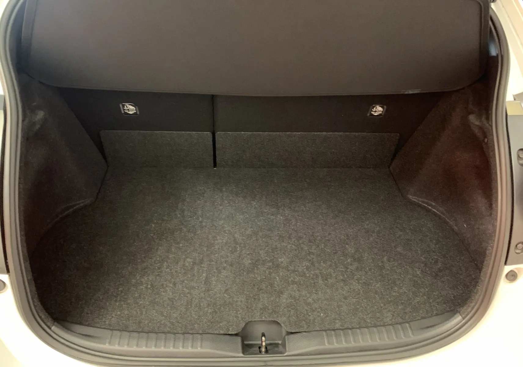 Coffre ouvert d'une Toyota Yaris 1.6 VVT-I 261 Premium GR blanc métal, montrant un espace de rangement propre et vide.