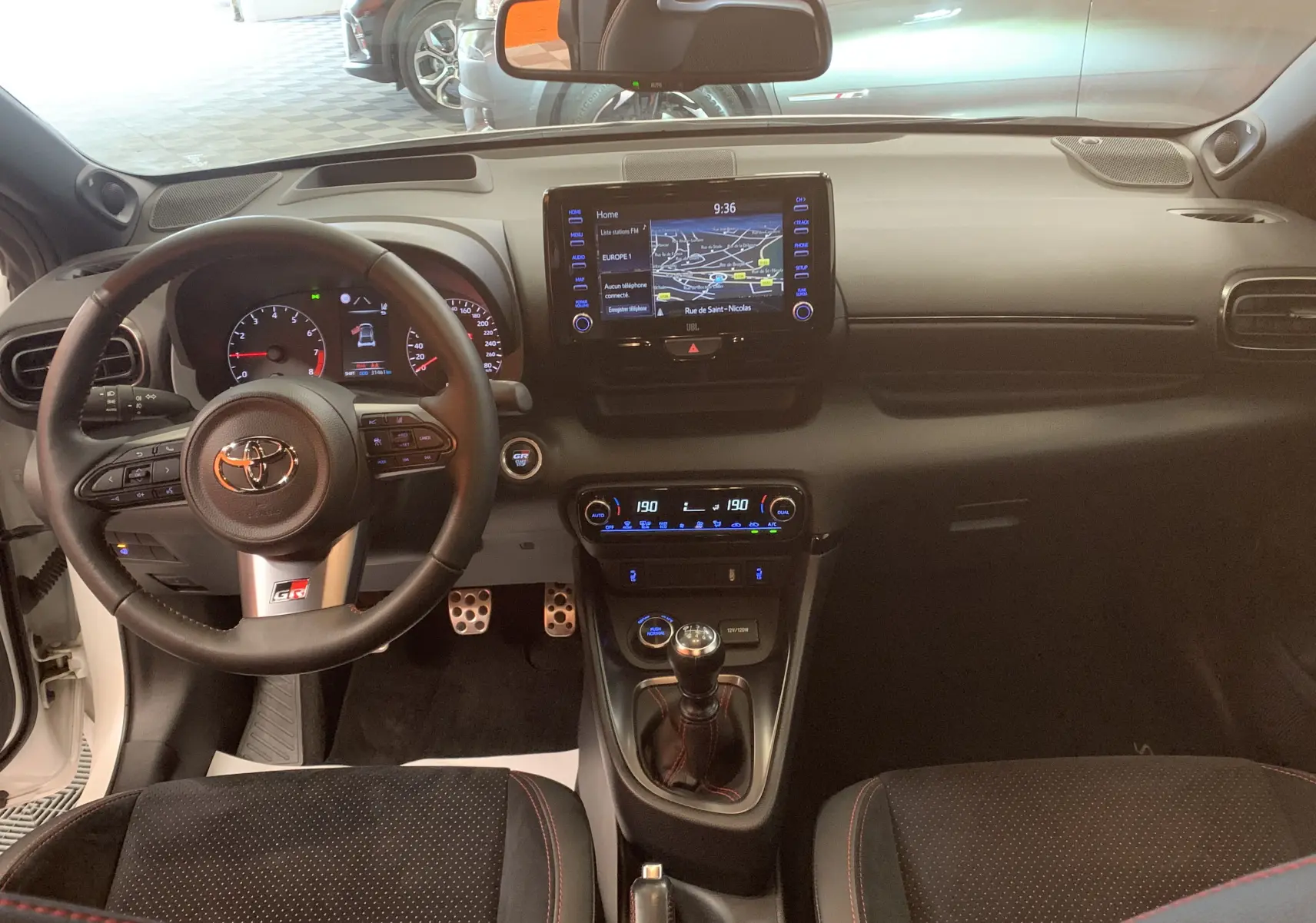 Vue intérieure de la Toyota Yaris 1.6 VVT-I 261 Premium GR 2021, tableau de bord et volant sport avec écran tactile GPS.