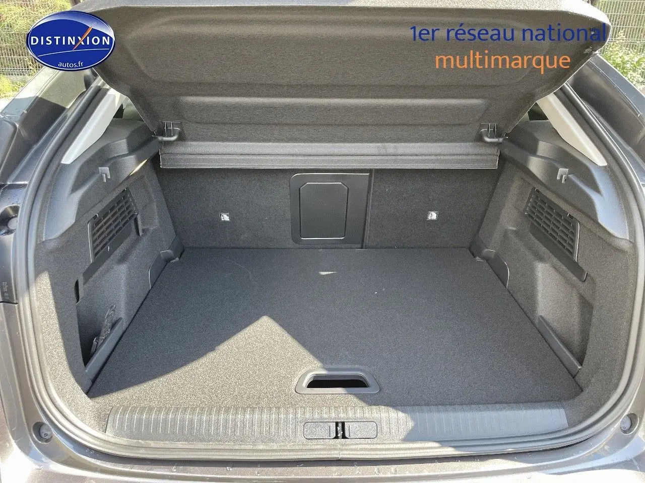 Coffre ouvert en vue arrière d'une Citroën C4 gris platinium métal, montrant un espace de chargement propre et spacieux.