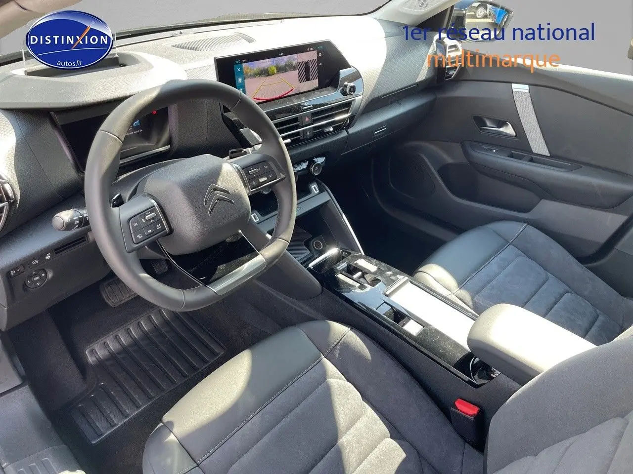 Intérieur de la Citroën C4 2024 en gris, vue côté conducteur avec volant multifonction et écran tactile central.