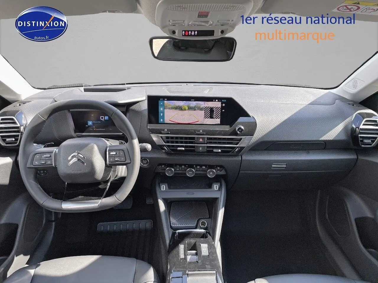 Vue intérieure avant du tableau de bord de la Citroën C4 2024 avec écran tactile et volant multifonction noir.