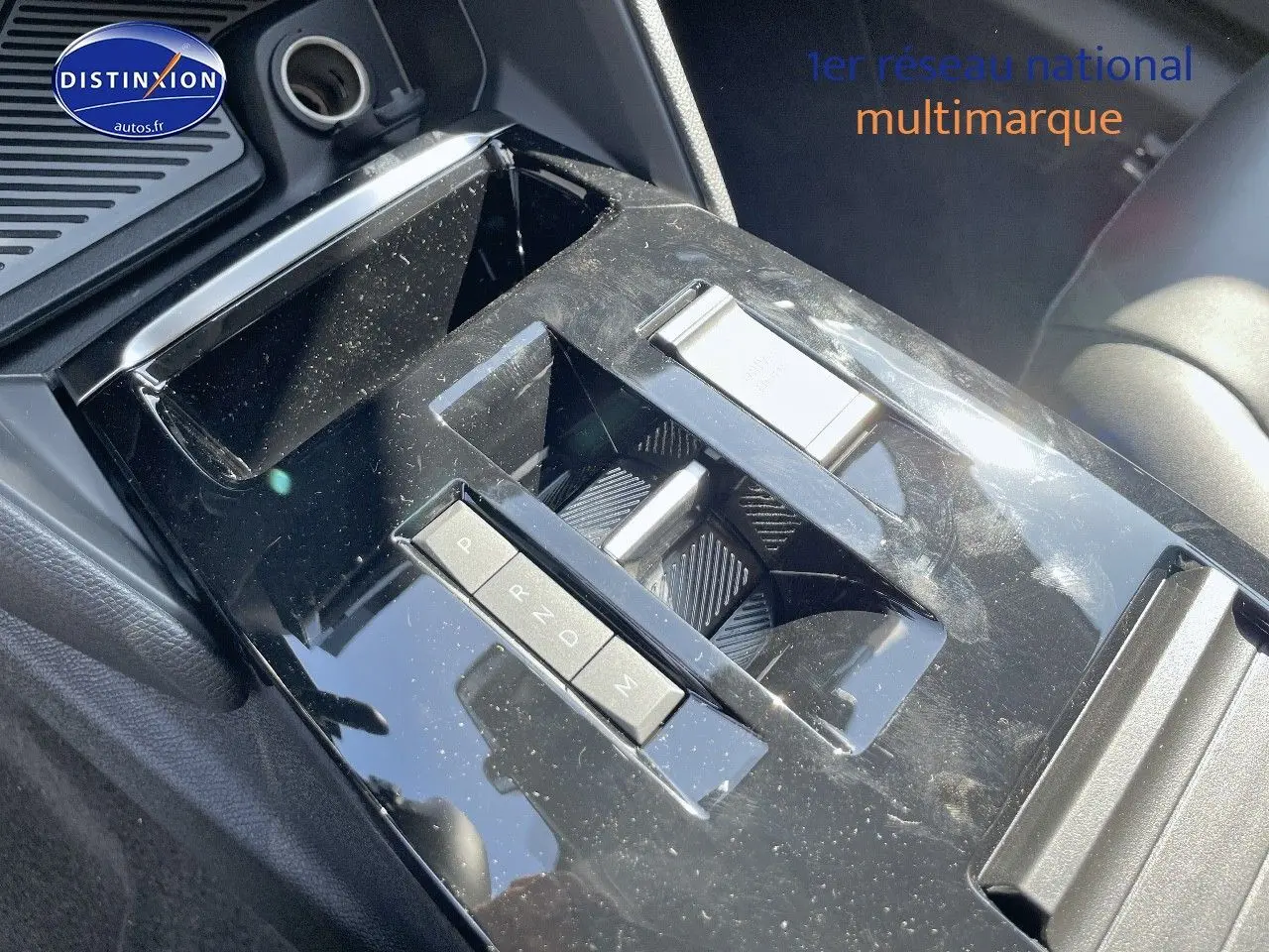 Gros plan sur la console centrale noire brillante avec levier de vitesses automatique de la Citroën C4 gris platinium 2024.
