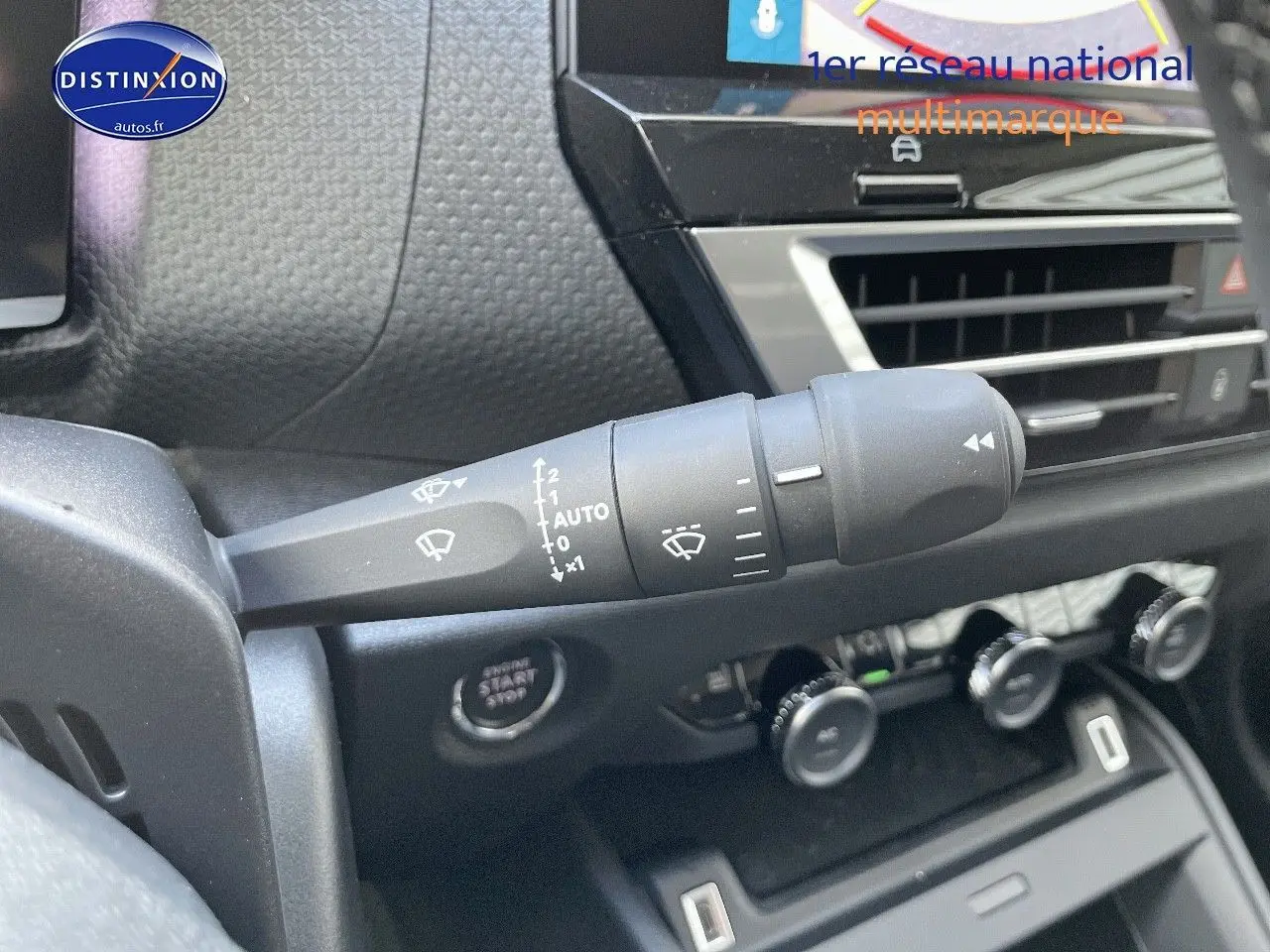 Gros plan sur la commande d'essuie-glace à gauche du volant dans l'habitacle d'une Citroën C4 gris platinium 2024.