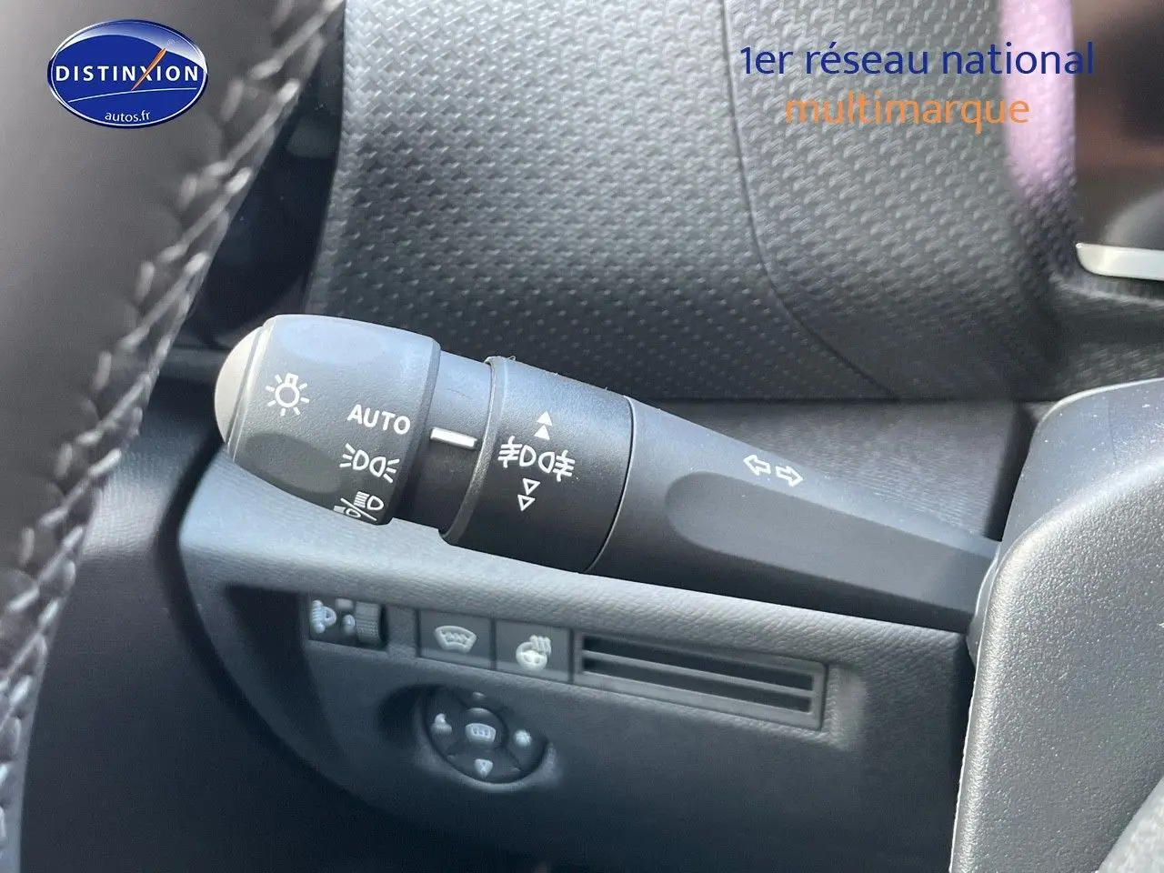 Gros plan sur la commande des feux et clignotants à gauche du volant dans un Citroën C4 gris platinium 2024.