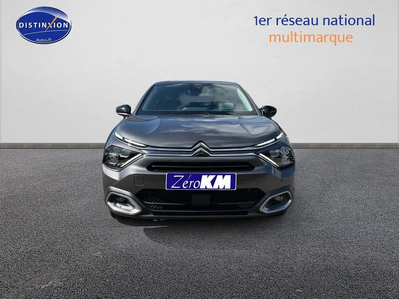 Vue frontale d'une Citroën C4 2024 gris platinium métal avec calandre distinctive et feux LED fins.