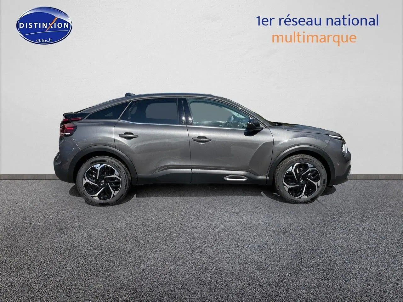 Profil latéral droit d'une Citroën C4 2024 gris platinium métallisé avec jantes bi-ton et lignes fluides.