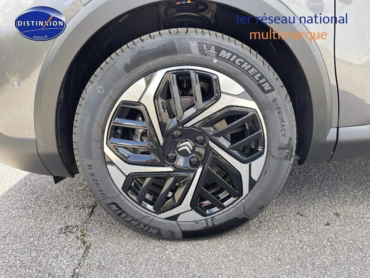 Gros plan sur la roue avant droite d'une Citroën C4 gris platinium métal avec jante alliage bicolore et pneu Michelin.