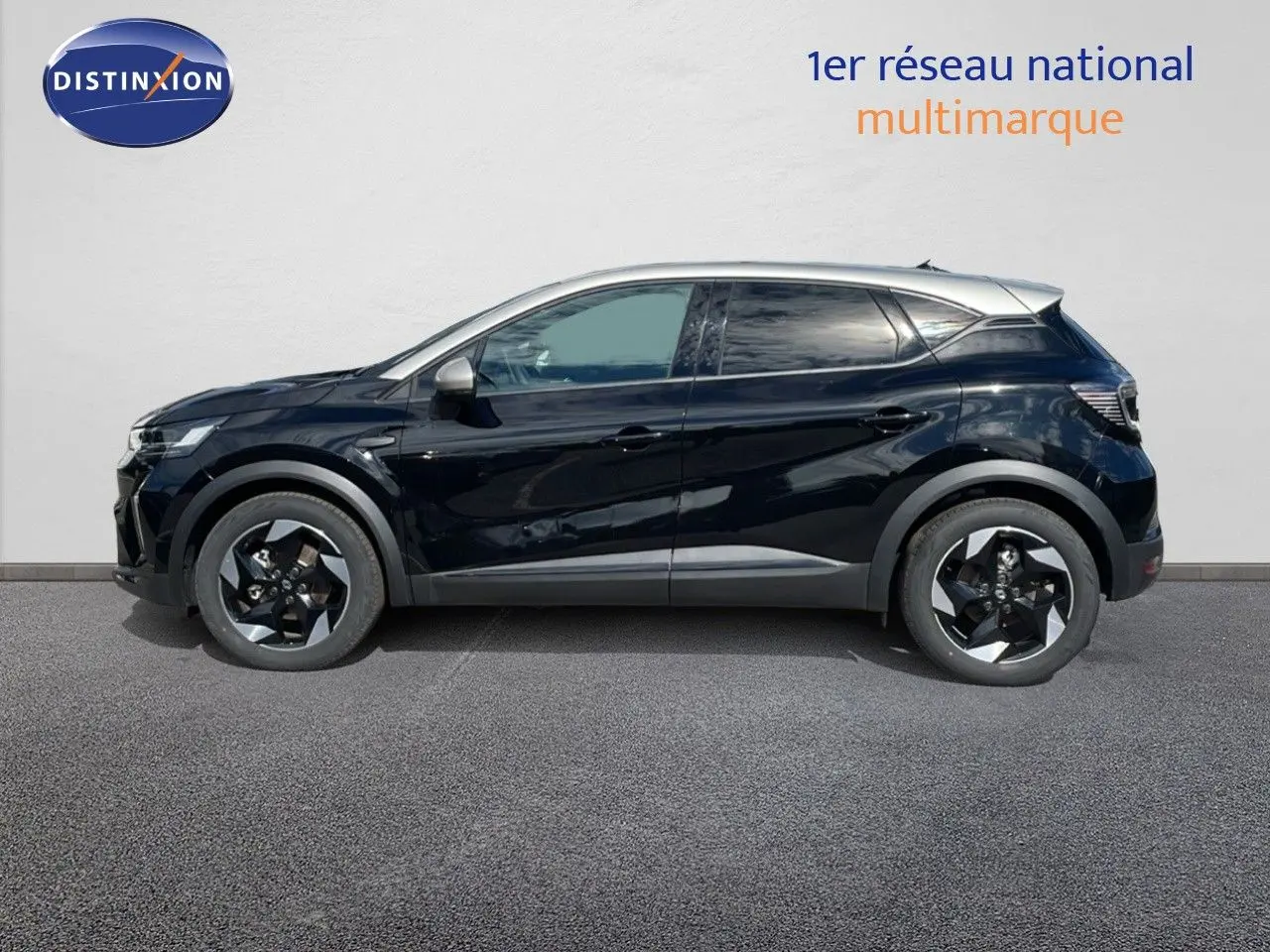 Profil droit d'un Renault Captur E-Tech hybride 2025 noir étoile avec toit gris et jantes bicolores.