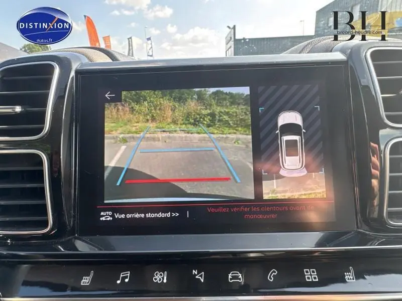 Écran central du tableau de bord montrant la caméra de recul et l’aide au stationnement du Citroën C5 Aircross blanc nacré.