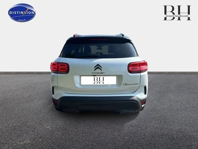 Vue arrière d'un Citroën C5 Aircross blanc nacré avec feux LED et attelage visible, sur fond neutre.