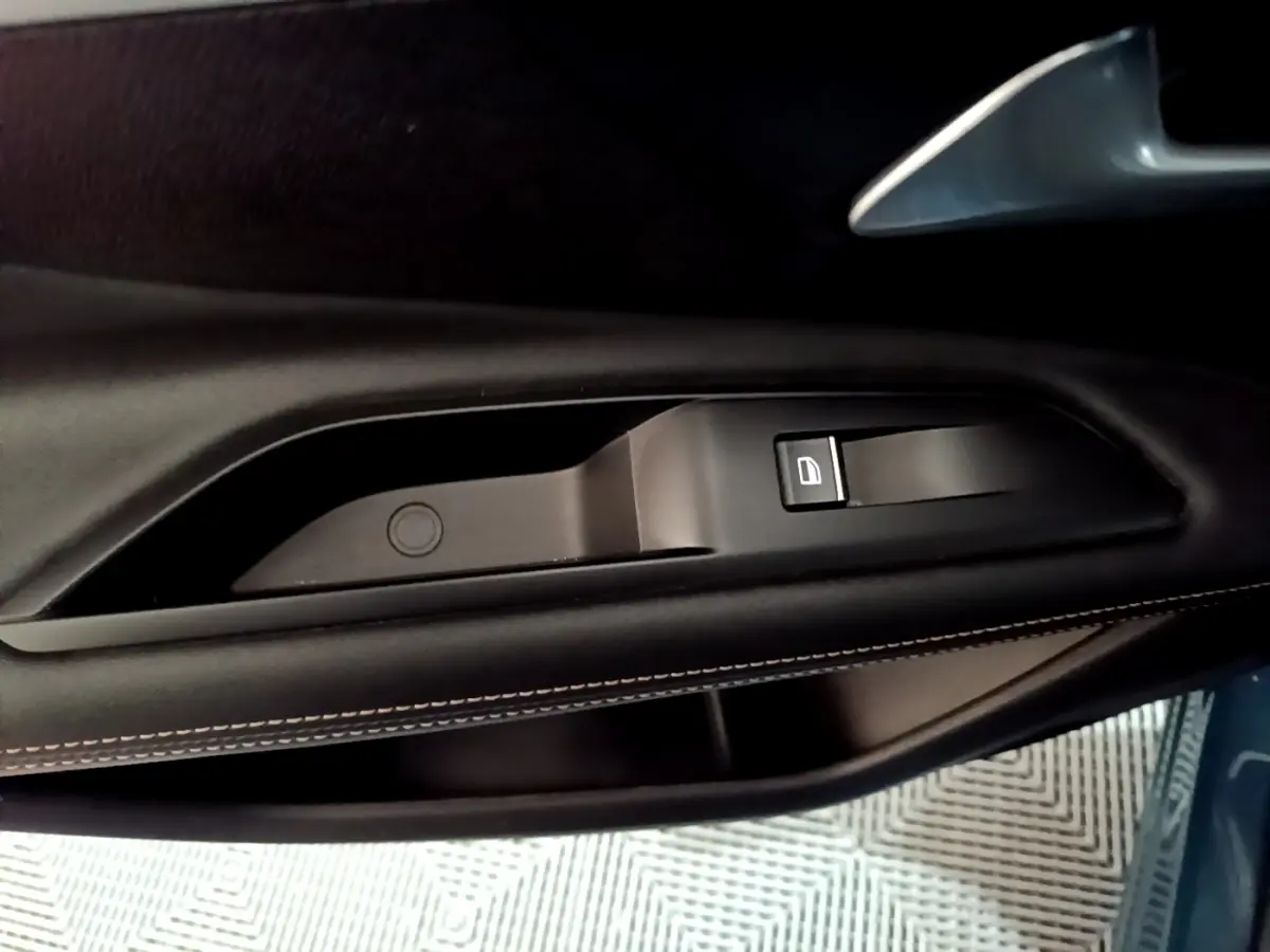 Gros plan sur la poignée intérieure côté gauche en cuir noir avec bouton de verrouillage, Peugeot 3008 bleu 2021.