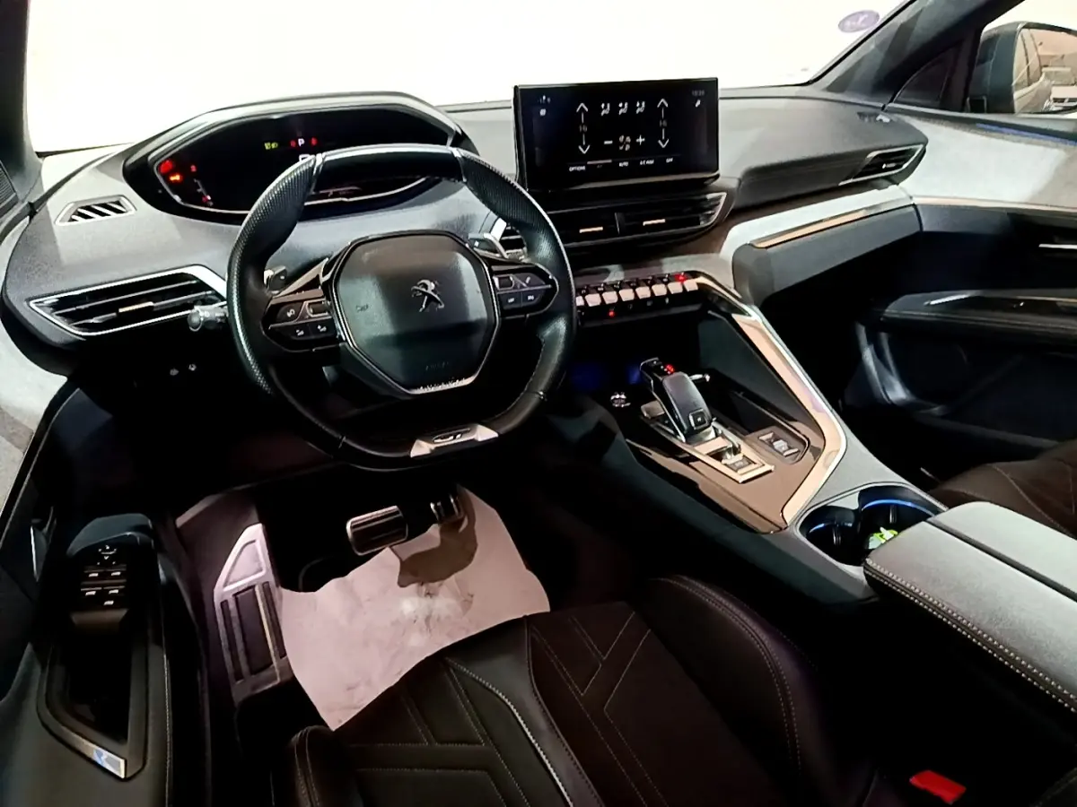 Vue intérieure côté conducteur du Peugeot 3008 GT 2021, volant cuir multifonctions et écran tactile central lumineux.