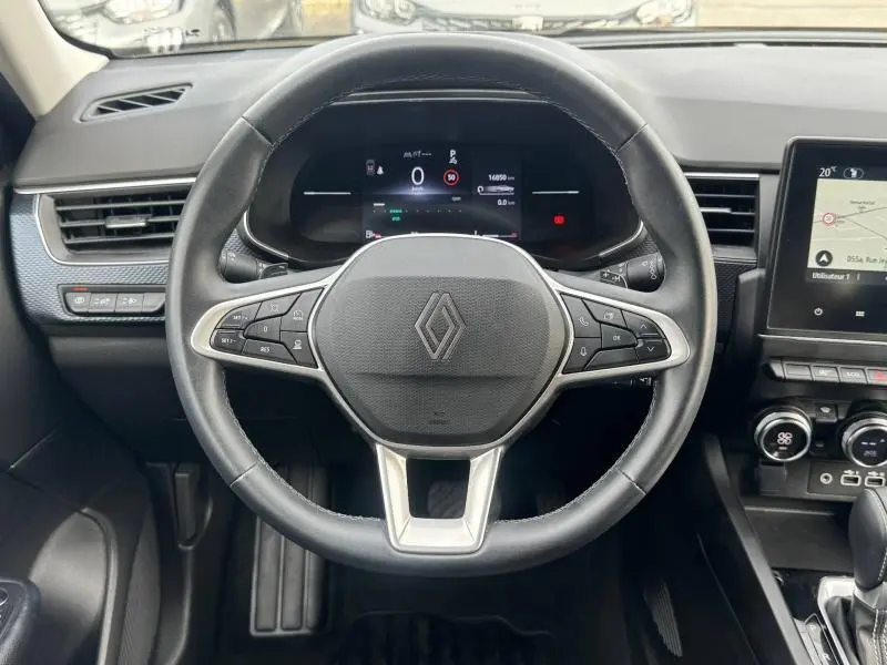 Vue centrée sur le volant du Renault Arkana 2025 blanc, avec tableau de bord numérique et commandes intégrées.