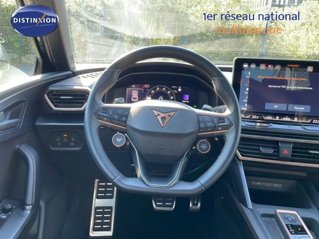 Vue intérieure centrée sur le volant cuir multifonction et l'écran tactile du tableau de bord d'une CUPRA Leon 2025.