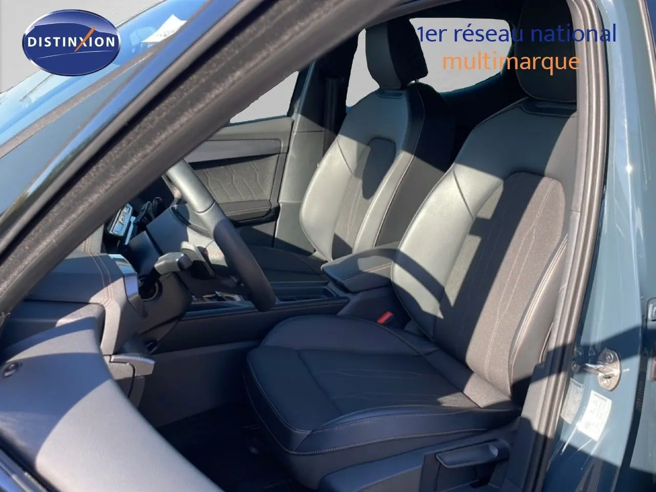 Vue intérieure côté conducteur de la CUPRA Leon 1.5 eTSI 150CH DSG 2025 en bleu Fjord, sièges cuir et tissu noirs.