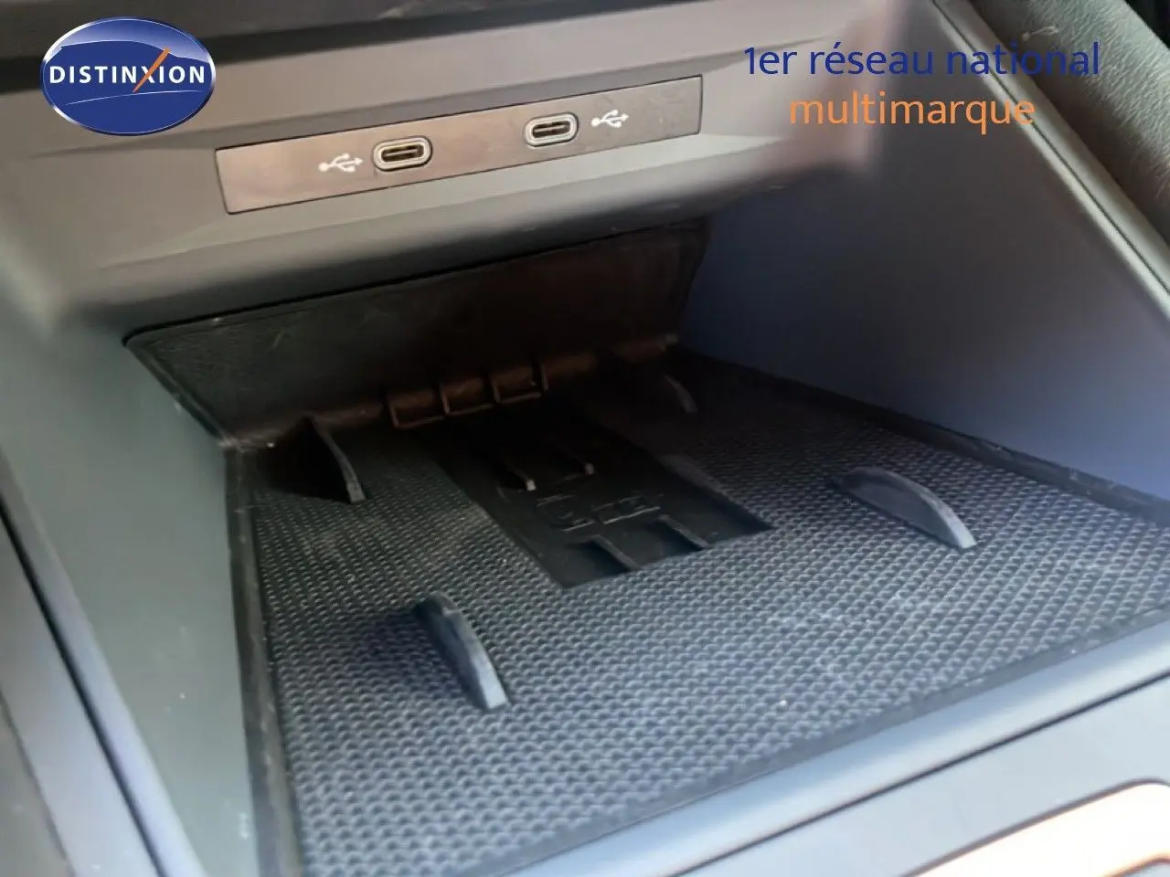 Gros plan sur la console centrale du CUPRA Leon 2025 montrant les ports USB-C et un espace de rangement en caoutchouc noir.