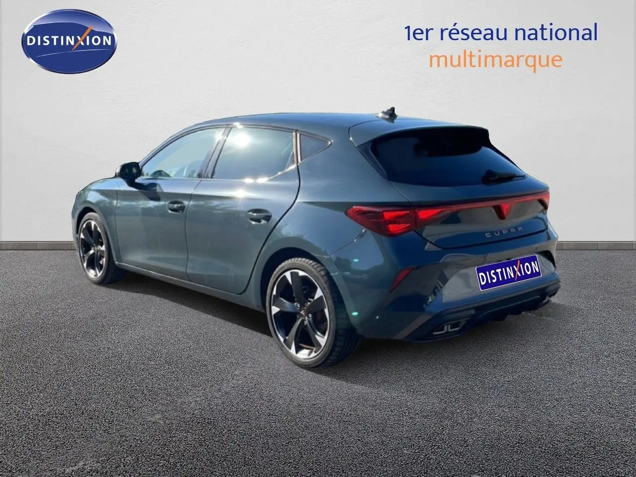 Vue 3/4 arrière droite d'une CUPRA Leon 1.5 eTSI 150CH DSG bleu Fjord avec jantes noires bicolores.